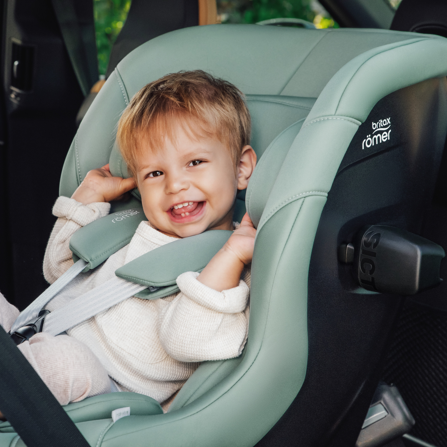 Crian&ccedil;a sorridente segura na cadeirinha auto MAX-SAFE PRO em Jade Green.