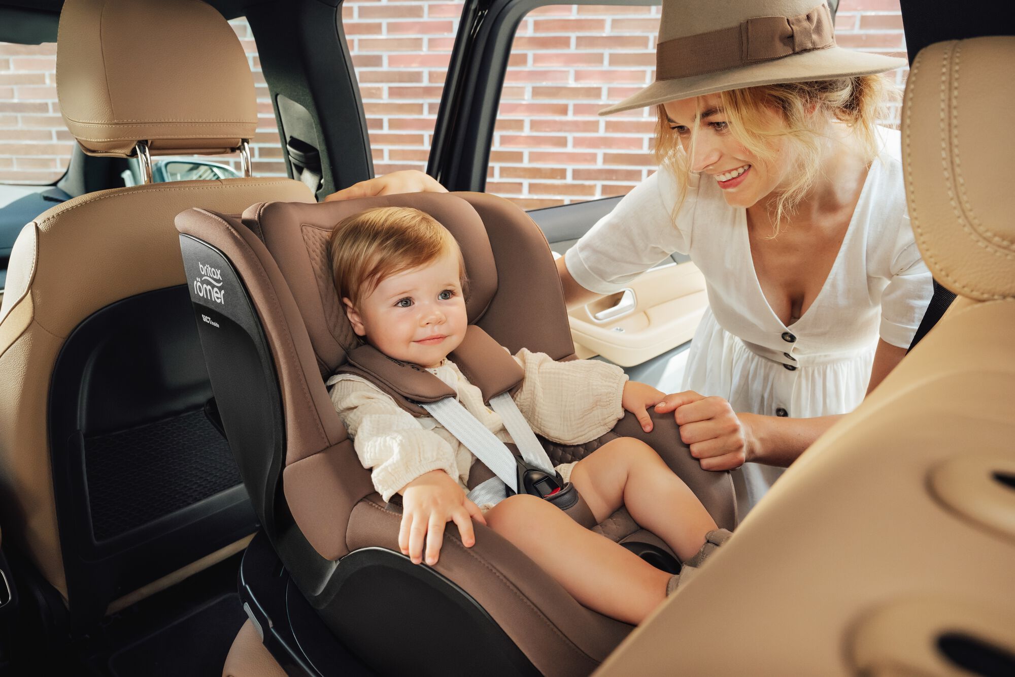 Criança pequena presa em uma cadeirinha DUALFIX 5Z toddler car seat, com a mãe ao seu lado.