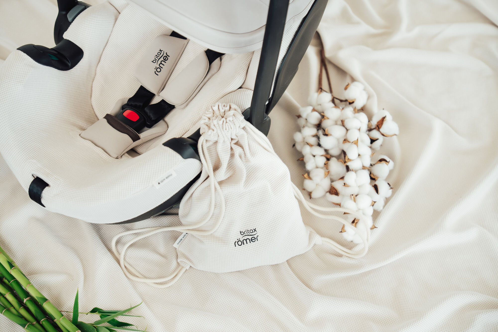 Capa de verão BABY-SAFE PRO em uma cadeirinha de bebé, com tecido respirável, saco com cordão a condizer e detalhes em algodão macio.